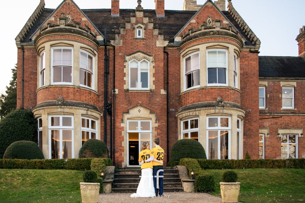 New bride and groom having a moment before entering their wedding breakfast wearing their personalised Mr and Mrs Wolverhampton Wanderers FC shirts